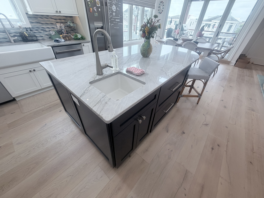 Kitchen island with a stone-look top and farmhouse sink