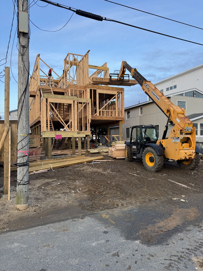 Wall framing rising as the telehandler stages material