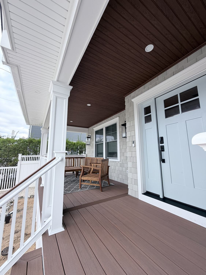 Porch seating under the stained beadboard ceiling