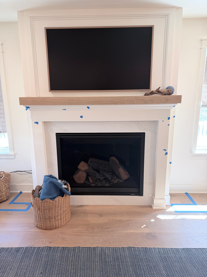 Fireplace with a painted surround and wood mantel